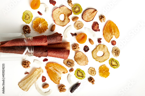 Above view of delicious fruit and berries lozenge and dried orange, apricot, raisins, walnuts, dried apples and kiwi on white background. Concept of healthy assorted dried fruit for snacks.