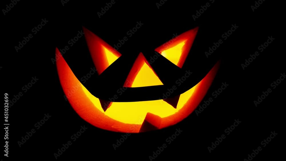 Scary face on blinking on black background. Jack-o-lantern glowing in the dark. Halloween pumpkin Scary face on blinking on black background. Jack-o-lantern glowing in the dark. Halloween pumpkin