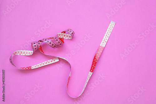 measuring tape on pink background