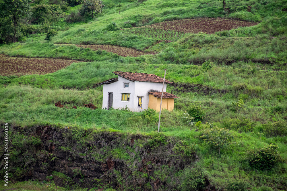 Stock photo of a single white painted house surrounded by green covered cultivation land. Electric pole placed near the house. red clay made tiles on the roof top of the house. Green mountain range Stock photo of a single white painted house surrounded by green covered cultivation land. Electric pole placed near the house. red clay made tiles on the roof top of the house. Green mountain range