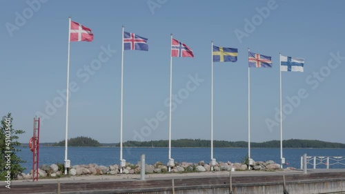 Six nordic country flags waving in a wind. Denmark, Iceland, Norway, Sweden, Åland and Finland National Flag. Shot in Finland in the nortwest archipelago area in summer. photo