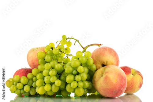 One ripe bunch of seedless grapes and several peaches   close-up  isolated on white.
