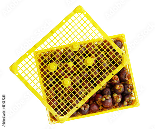 Mangosteens in a yellow box basket ready for export agriculter product. Isolated photo on white background. photo