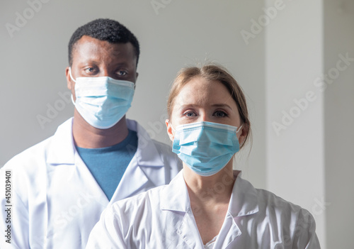 Diverse male and female doctors in white medical masks