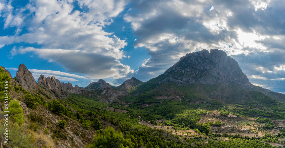 mountains and a beautiful sky with rays of sun over the mountain Puig Campana. Mount Castellet on the left. Landscape located in Finestrat, located in the Valencian Community, Alicante, Spain