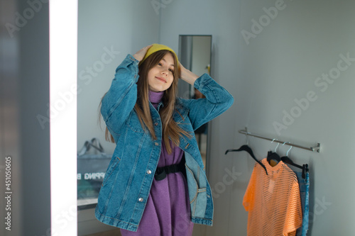 Young woman try on clothes in dressing room with mirror in shop. photo