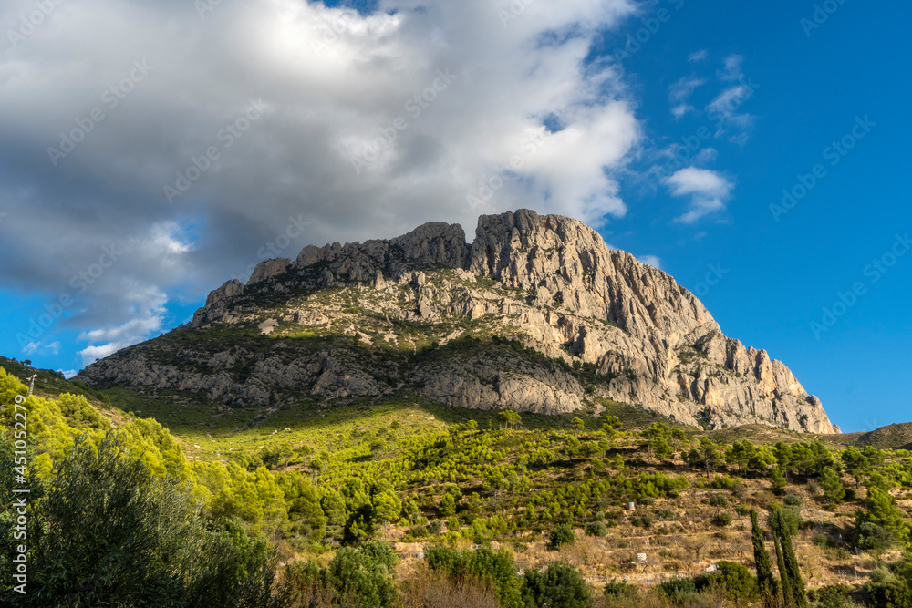 imposing mountain Puig Campana with a blue cloudy sky. Landscape located in Finestrat, located in the Valencian Community, Alicante, Spain