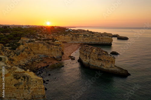 Atlanic ocean coastline in Portugal Algarve near Albufeira, rocky cliffs with visible erosion, landscape aerial photo during sunrise. Beautiful holiday place with the sea, rocks outdoor trekking