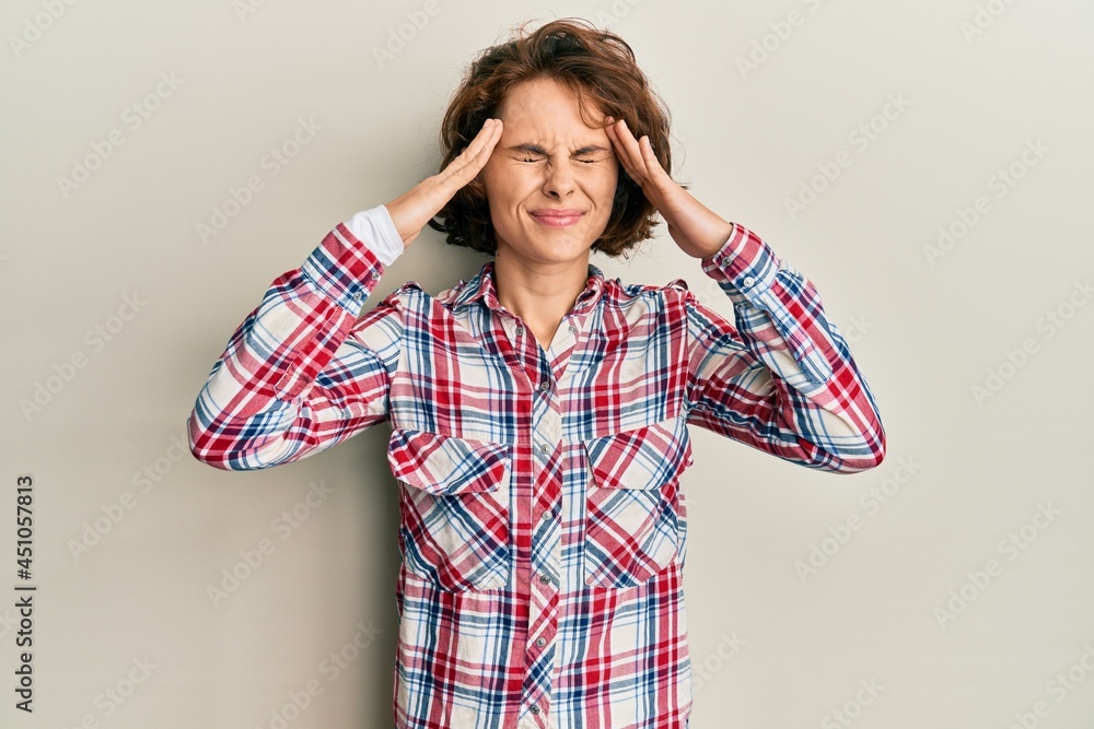Young brunette woman wearing casual clothes with hand on head, headache because stress. suffering migraine. Young brunette woman wearing casual clothes with hand on head, headache because stress. suffering migraine.