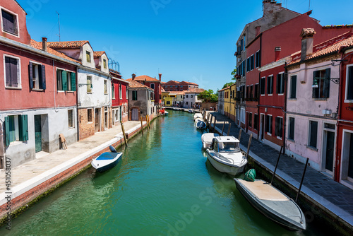 Beautiful houses and boats along a narrow canal in Venice, Italy.