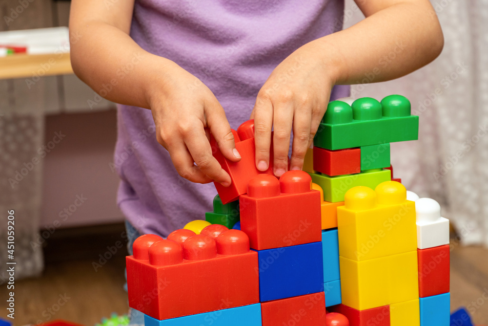 Fototapeta premium kid, child hands, while playing with educational toy blocks constructor