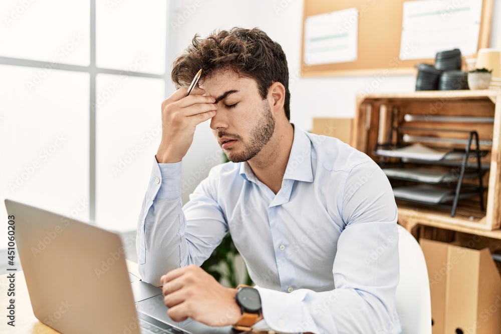 Young hispanic businessman overworked working at the office. Young hispanic businessman overworked working at the office.