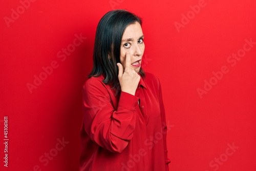 Middle age hispanic woman wearing casual clothes pointing to the eye watching you gesture, suspicious expression © Krakenimages.com