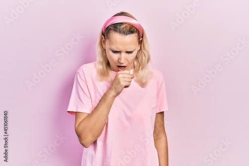 Beautiful caucasian blonde woman wearing casual pink t shirt feeling unwell and coughing as symptom for cold or bronchitis. health care concept.