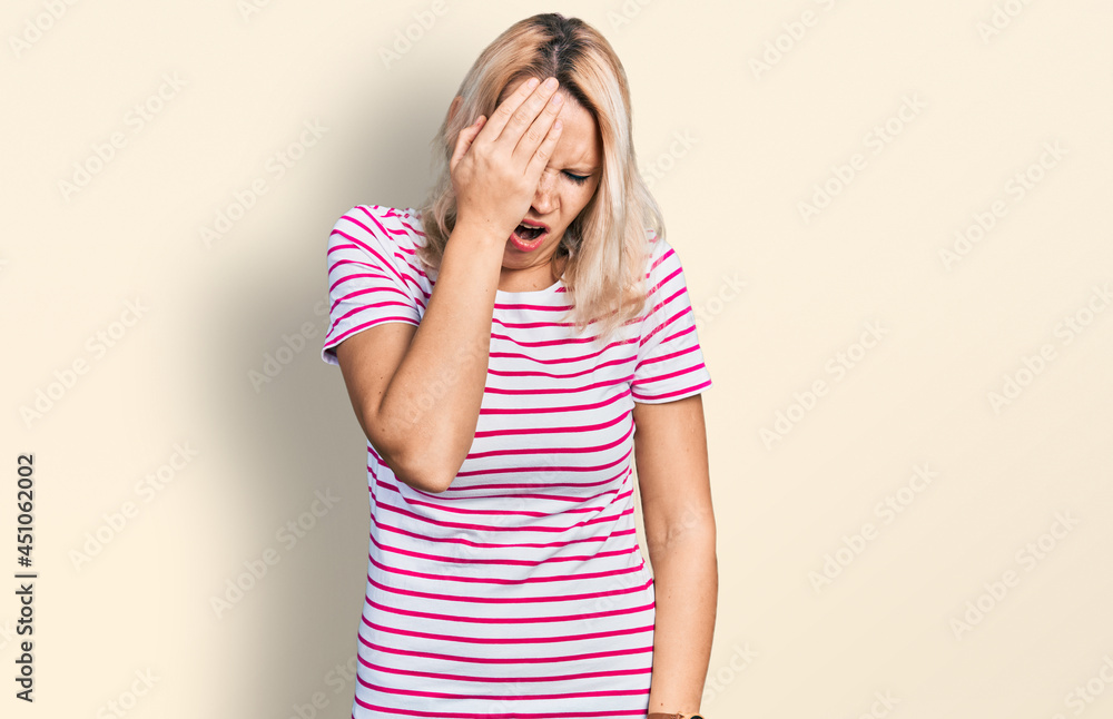 Young caucasian woman wearing casual clothes yawning tired covering half face, eye and mouth with hand. face hurts in pain. Young caucasian woman wearing casual clothes yawning tired covering half face, eye and mouth with hand. face hurts in pain.