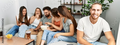 Group of young friends smiling happy watching movie at home.