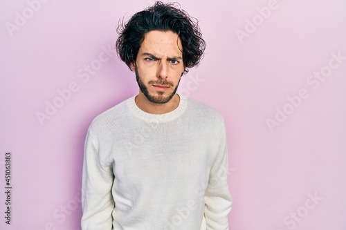 Handsome hispanic man wearing casual white sweater skeptic and nervous, frowning upset because of problem. negative person. © Krakenimages.com
