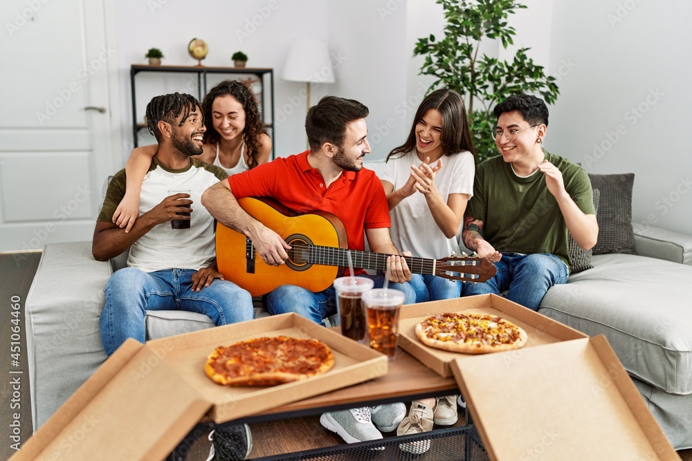 Group of young friends having party eating italian pizza and playing classical guitar at home. Group of young friends having party eating italian pizza and playing classical guitar at home.
