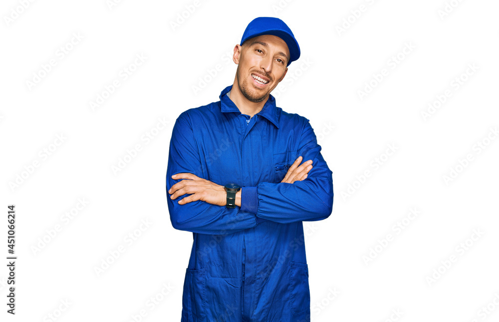 Bald man with beard wearing builder jumpsuit uniform happy face smiling with crossed arms looking at the camera. positive person. Bald man with beard wearing builder jumpsuit uniform happy face smiling with crossed arms looking at the camera. positive person.