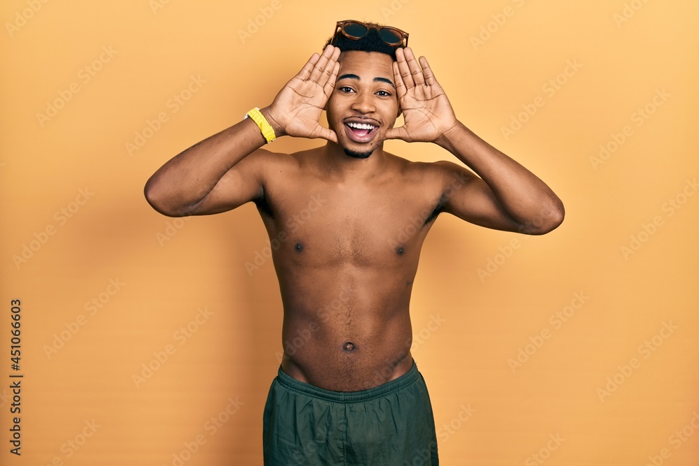 Young african american man wearing swimwear and swimmer glasses smiling cheerful playing peek a boo with hands showing face. surprised and exited Young african american man wearing swimwear and swimmer glasses smiling cheerful playing peek a boo with hands showing face. surprised and exited
