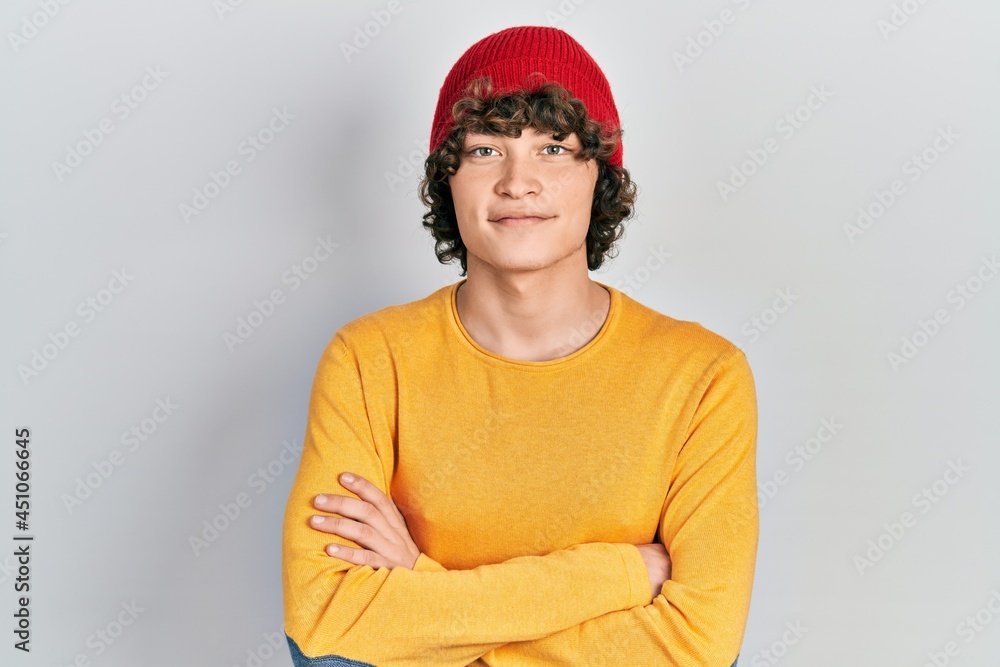 Handsome young man wearing wool hat happy face smiling with crossed arms looking at the camera. positive person. Handsome young man wearing wool hat happy face smiling with crossed arms looking at the camera. positive person.