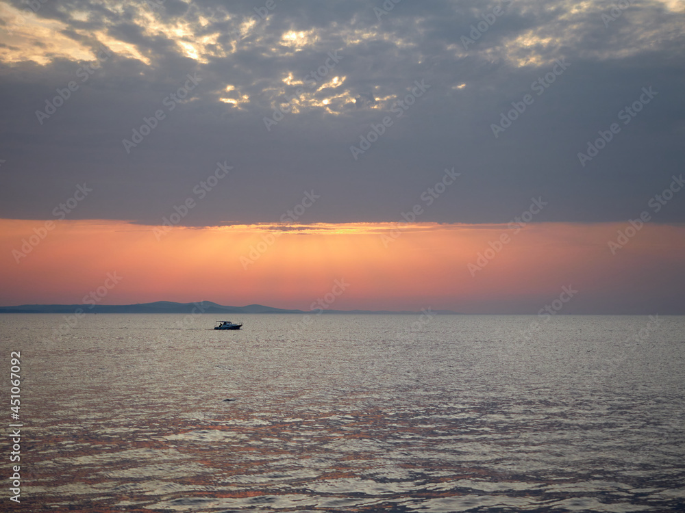 Zadar, Croatia, A boat in the sea in the rays of the setting sun. Beautiful sea landscape