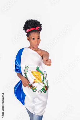 Attractive afro-American woman wrapped with a Guatemalan flag looking and pointing at the camera photo