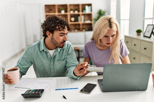 Young couple controlling family economy at home.