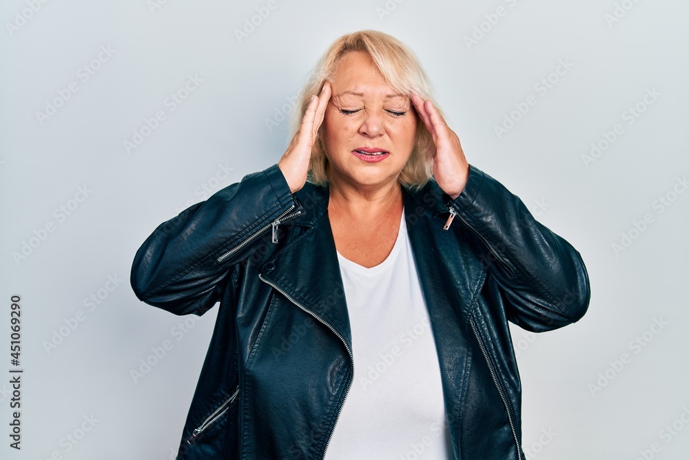 Middle age blonde woman wearing leather jacket with hand on head for pain in head because stress. suffering migraine. Middle age blonde woman wearing leather jacket with hand on head for pain in head because stress. suffering migraine.