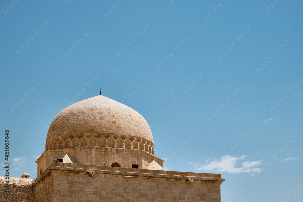 Dome of madrasah opposite summer blue sky. Kasimiye Medrese, Mardin, Turkey