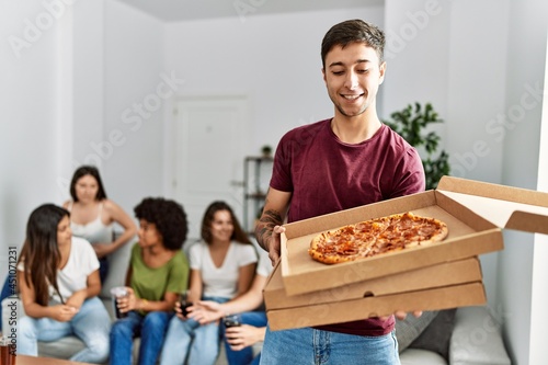 Wallpaper Mural Young man holding box of take away pizza standing at home. Torontodigital.ca