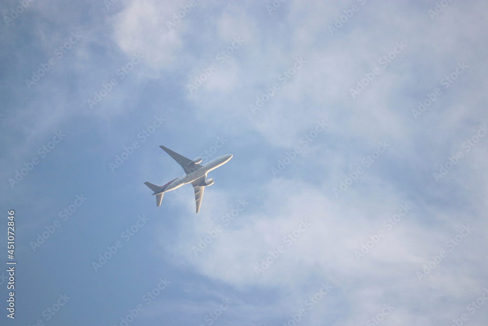 Airplane flying in the blue sky with white clouds. Passenger plane at flight, travel concept Airplane flying in the blue sky with white clouds. Passenger plane at flight, travel concept
