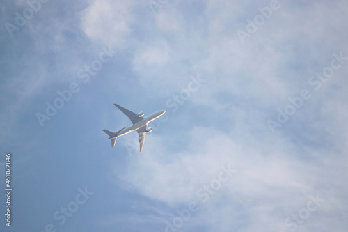 Airplane flying in the blue sky with white clouds. Passenger plane at flight, travel concept