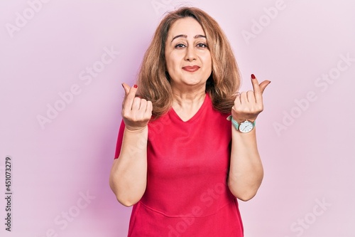 Middle age caucasian woman wearing casual clothes doing money gesture with hands, asking for salary payment, millionaire business