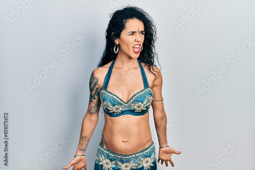 Young woman wearing bindi and traditional belly dance clothes angry and mad screaming frustrated and furious, shouting with anger. rage and aggressive concept.