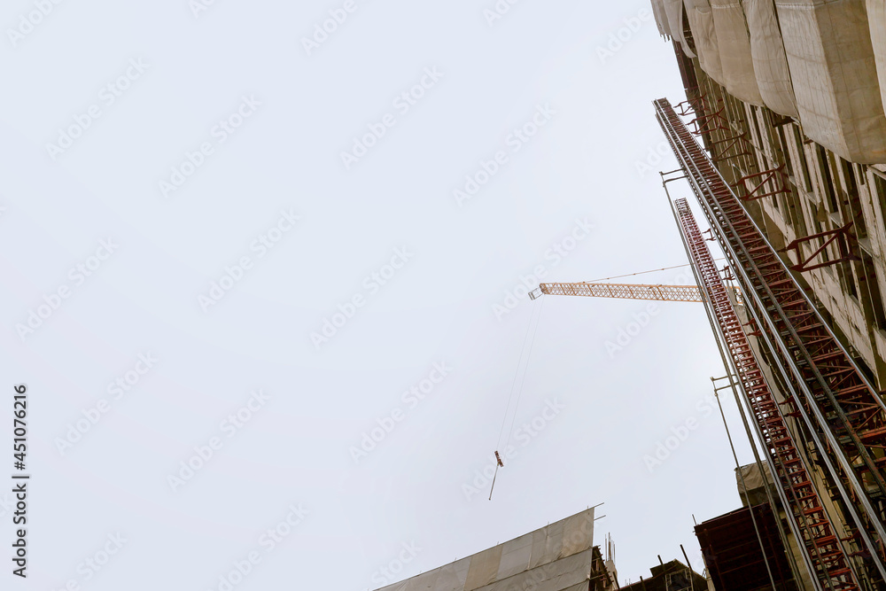 Obraz premium Construction crane and height building on white backgrounds