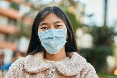 Young asian woman wearing medical mask standing at the city. © Krakenimages.com