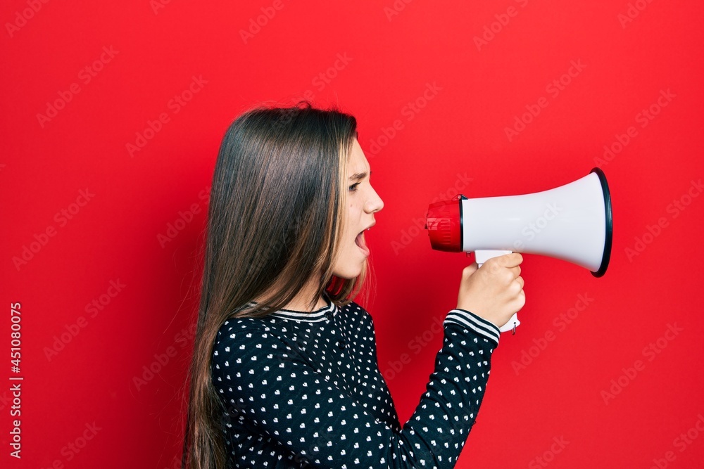 Young teenager girl shouthing and screaming with megaphone Young teenager girl shouthing and screaming with megaphone