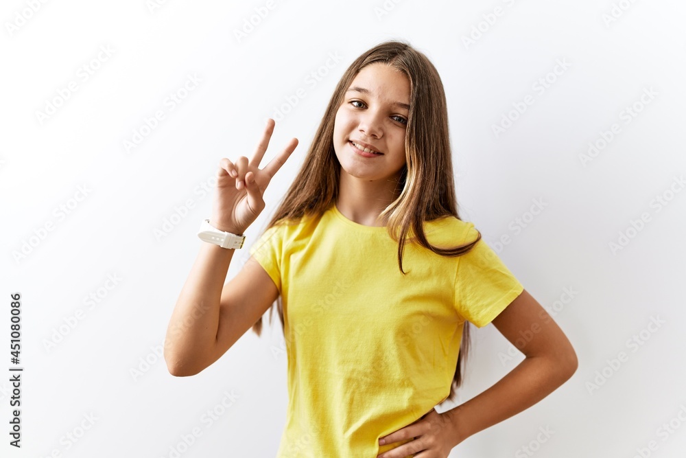 Fototapeta premium Young brunette teenager standing together over isolated background smiling looking to the camera showing fingers doing victory sign. number two.