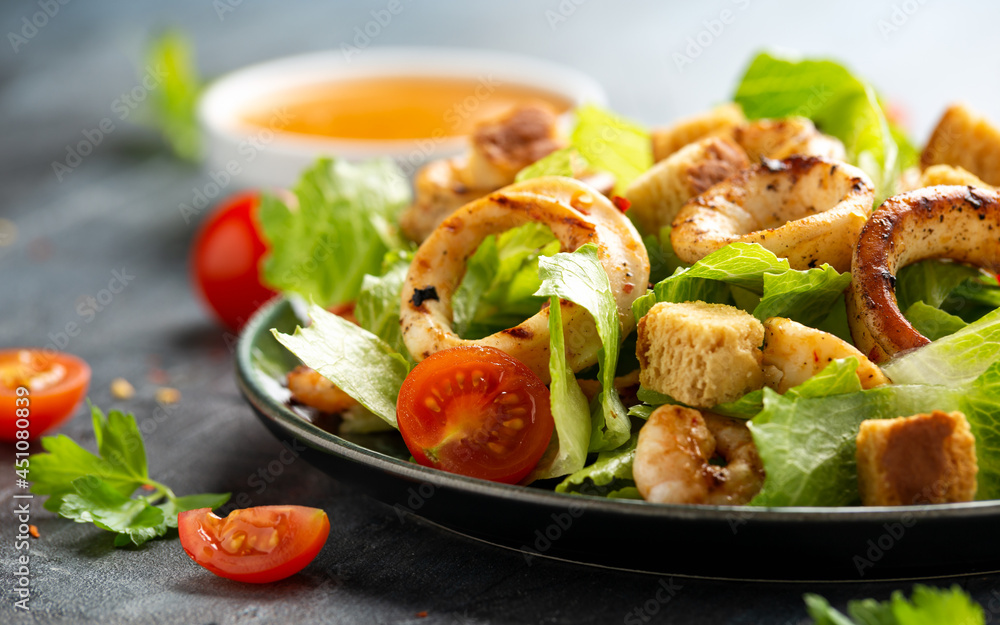 Grilled squid or calamari and prawns salad with garlic croutons and cherry tomatoes Grilled squid or calamari and prawns salad with garlic croutons and cherry tomatoes