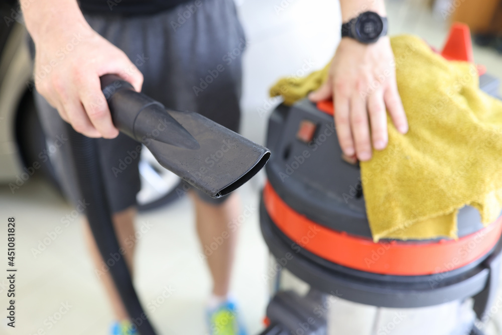 Man cleaner holding pipe from professional vacuum cleaner and microfiber cloth closeup