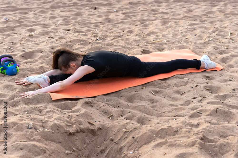 Girl gymnast trains on the beach by the sea. Photo series Girl gymnast trains on the beach by the sea. Photo series