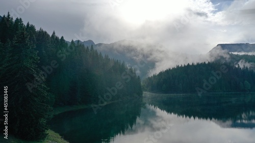 fog over the lake and forest in the front of mountains  photo