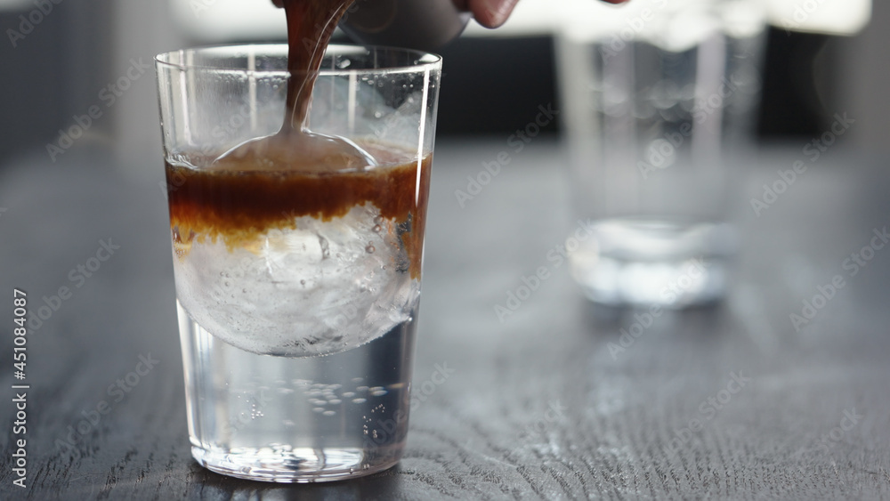 Making espresso tonic in tumbler with ice ball