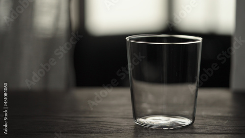 Empty tumbler glass on oak table