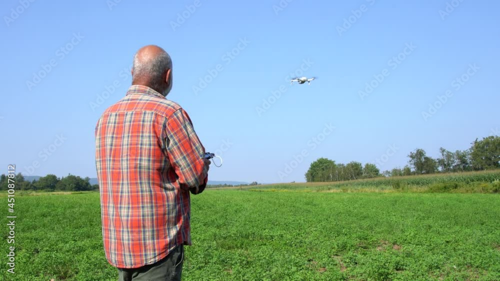 A 4K video of a farmer using a drone to check with agricultural farm fields. A 4K video of a farmer using a drone to check with agricultural farm fields.