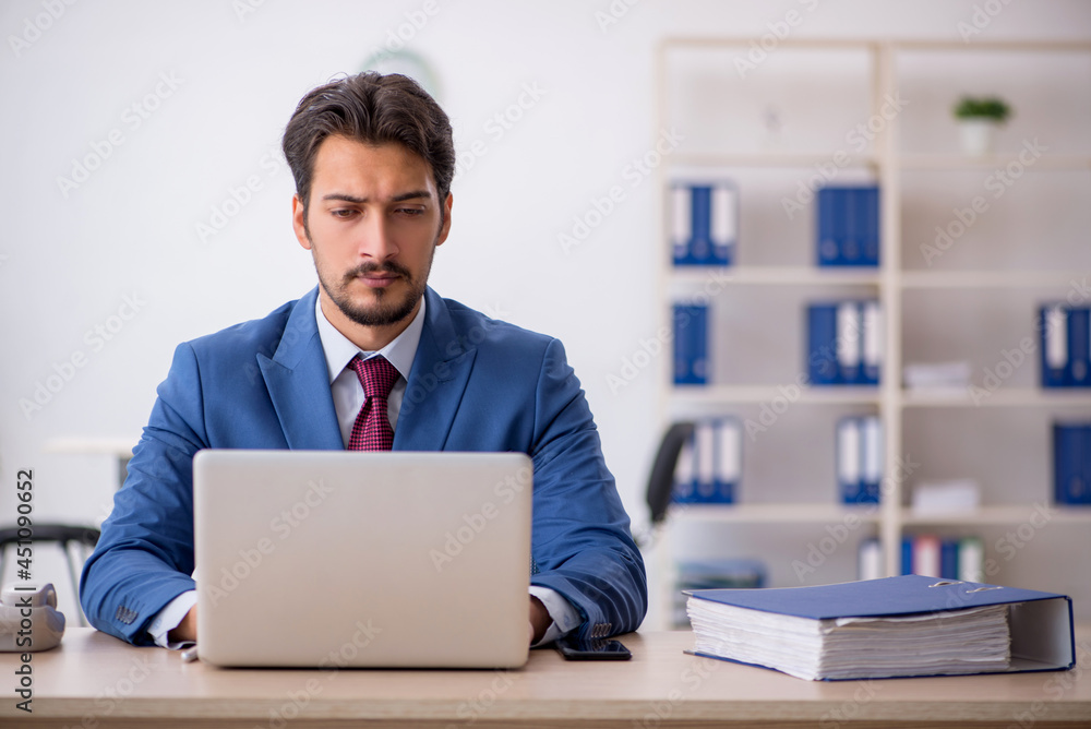 Young male employee working at workplace Young male employee working at workplace