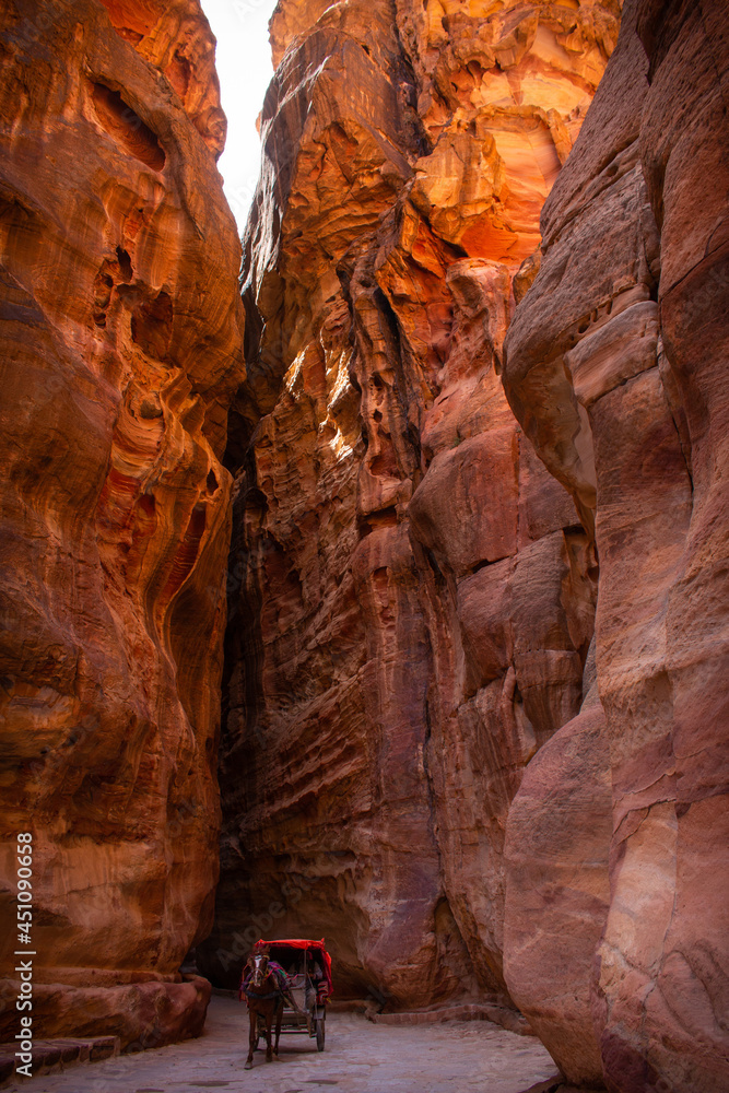A horse with a carriage in a gorge called the Siq that leads to Petra, Jordan A horse with a carriage in a gorge called the Siq that leads to Petra, Jordan