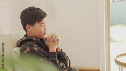 Billede på lærred Mixed Asian preteen teen boy praying with eyes closed, kid fellowship worshiping