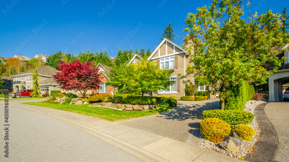 A perfect neighbourhood. Houses in suburb at Summer in the north America. Luxury houses with nice landscape.